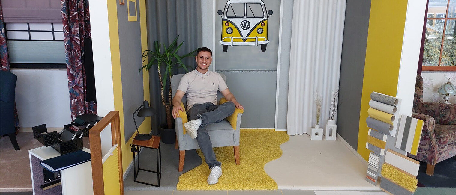 Mohamad Hanafi in seinem selbst gestalteten Raum für seine Meisterprüfung. An der Wand ein selbst gemalter VW-Bus von vorne.
