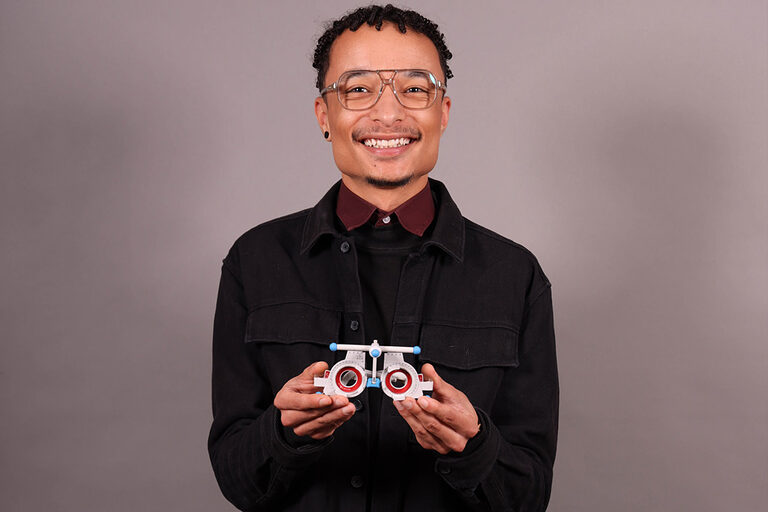 Halbtotale von Optiker, hält Brillenmodell in der Hand