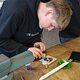 Besucher des Macher-Tags gestaltet ein Glas-Element in der Form von Yin und Yang
