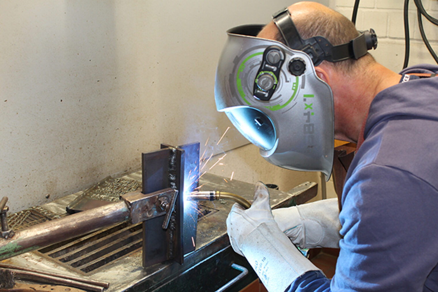 Teilnehmer beim MAG-Schweißen-Grundkurs in der Handwerkskammer Aschaffenburg: Fokus auf Schweißübung und Sicherheit.