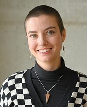 Portrait: Frau mit kurzen Haaren lächelt, trägt SW-karierter Pullover Portrait: Frau mit kurzen Haaren lächelt in die Kamera, Schwarz-Weiß karierter Pullover