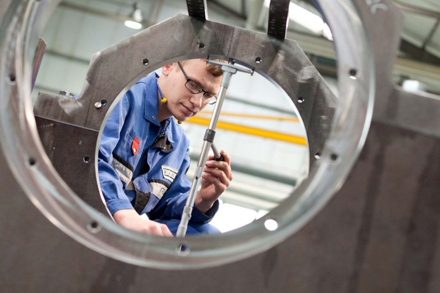 Metallbauer in Schutzkleidung richtet ein Stab aus Metallbauer in Schutzkleidung richtet ein Stab aus