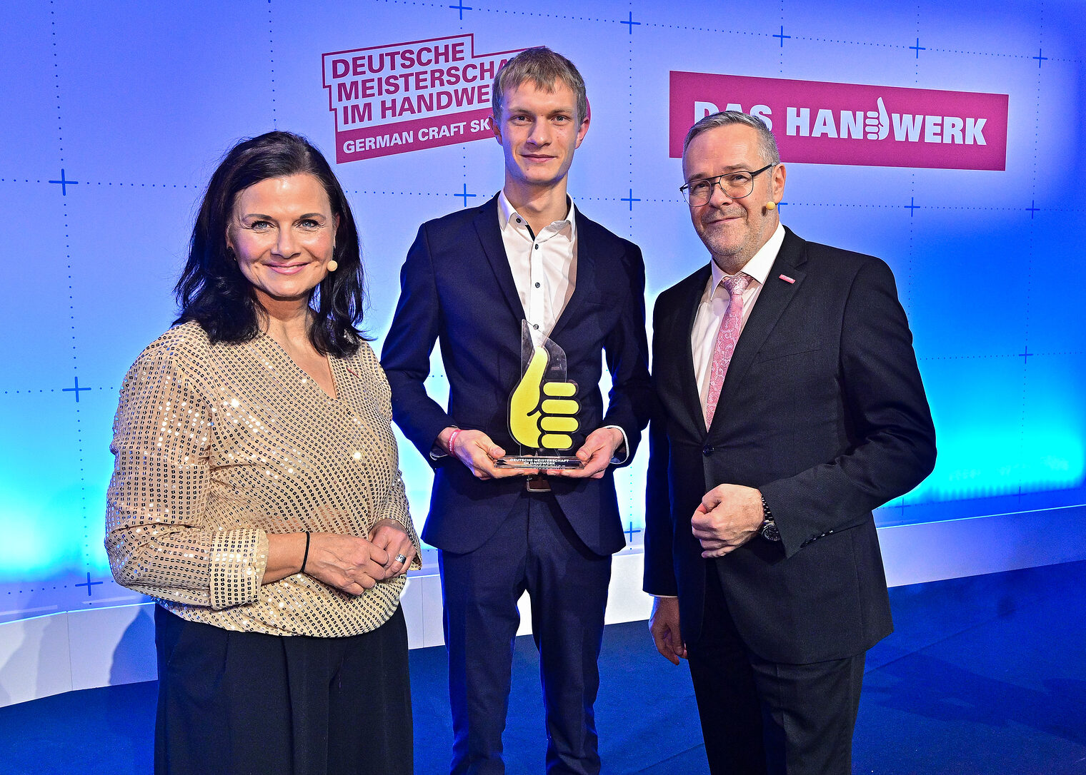 Gruppenfoto drei Personen auf Bühne