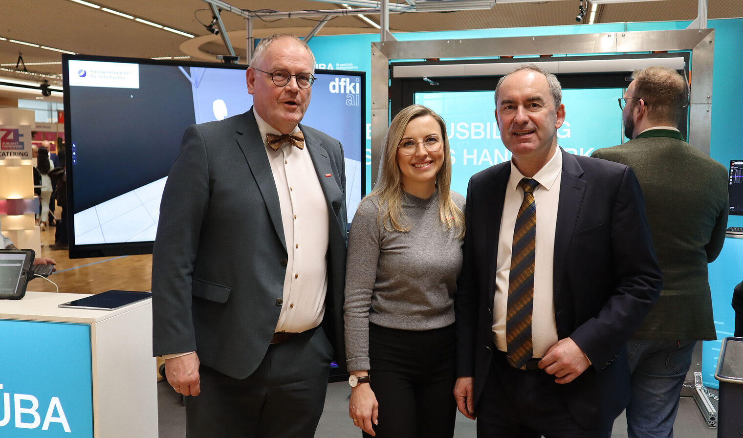 Gruppenfoto auf Messe, drei Personen