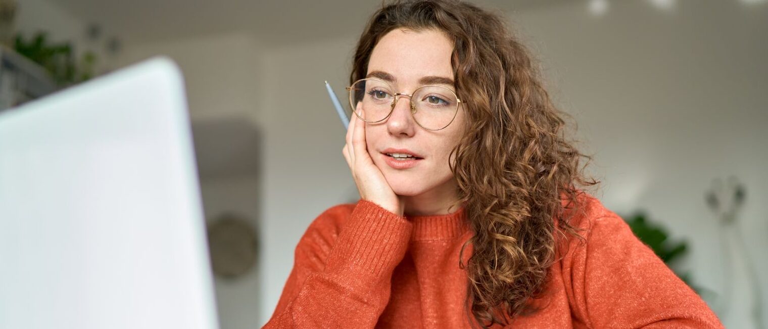Junge Frau lernt am Computer in einer ruhigen Umgebung. Symbol für digitales Lernen und Karriereentwicklung.
