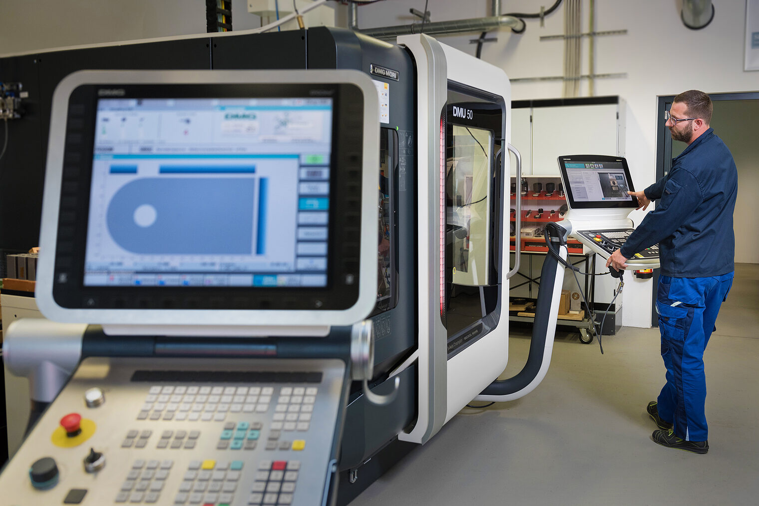 CNC-Maschine Bildschirm, Handwerker steht davor und mach Einstellungen